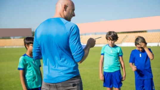 Istruttore che insegna calcio